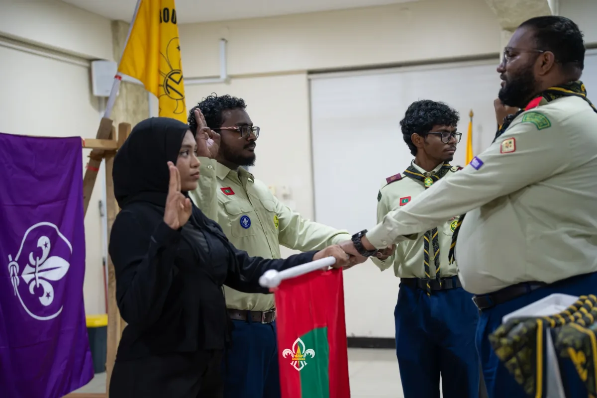 Two new Rovers make their Scout Promise while holding the Maldives flagpole.