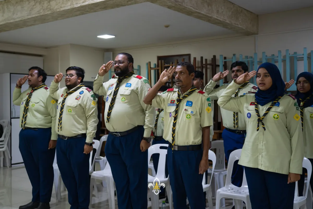 Rovers and leaders stand together giving the Scout salute.