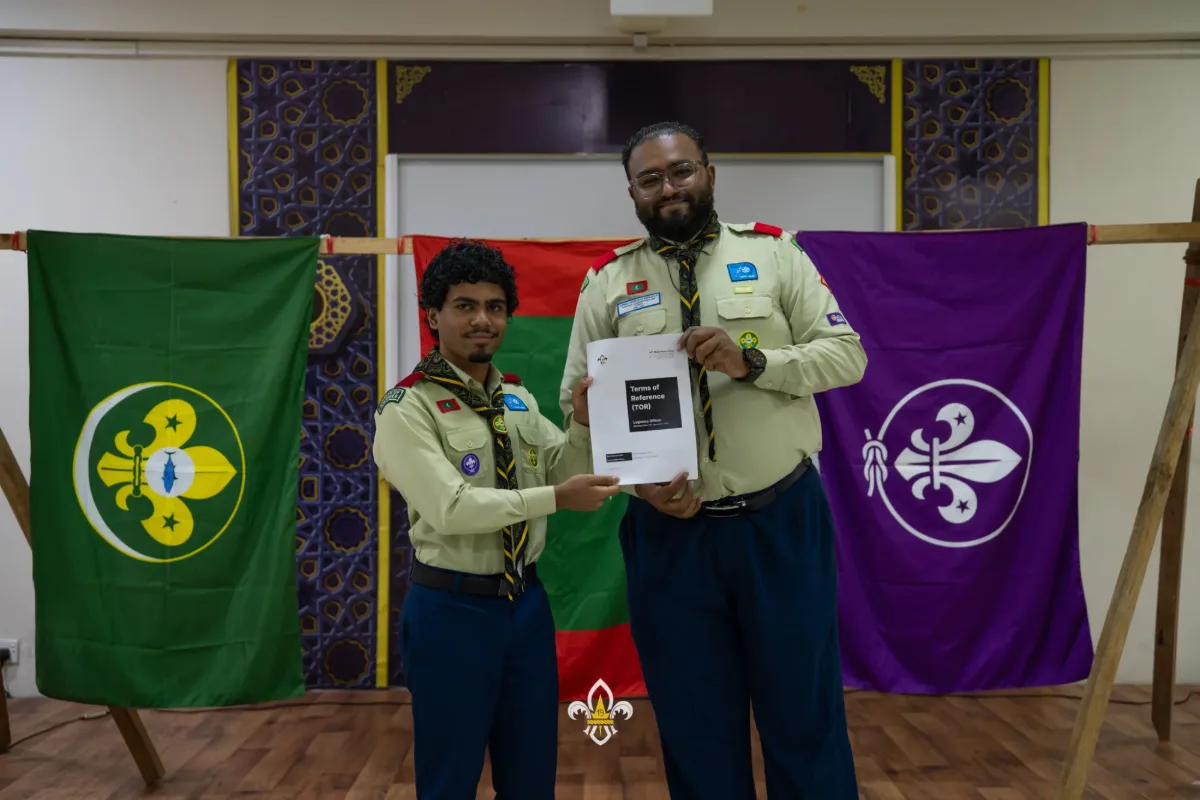 The Rover Advisor and an EXCO officer display the Terms of Reference following the handover.