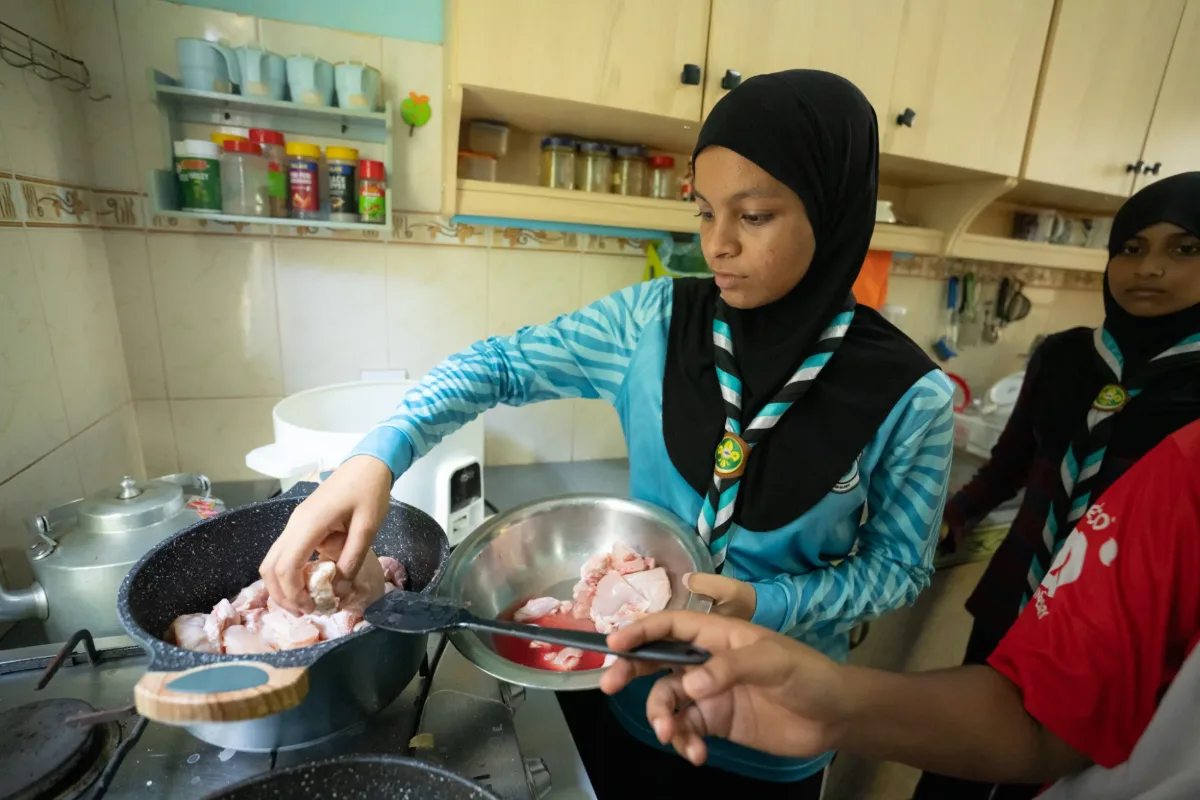 Scouts preparing and cooking a meal together during the camp