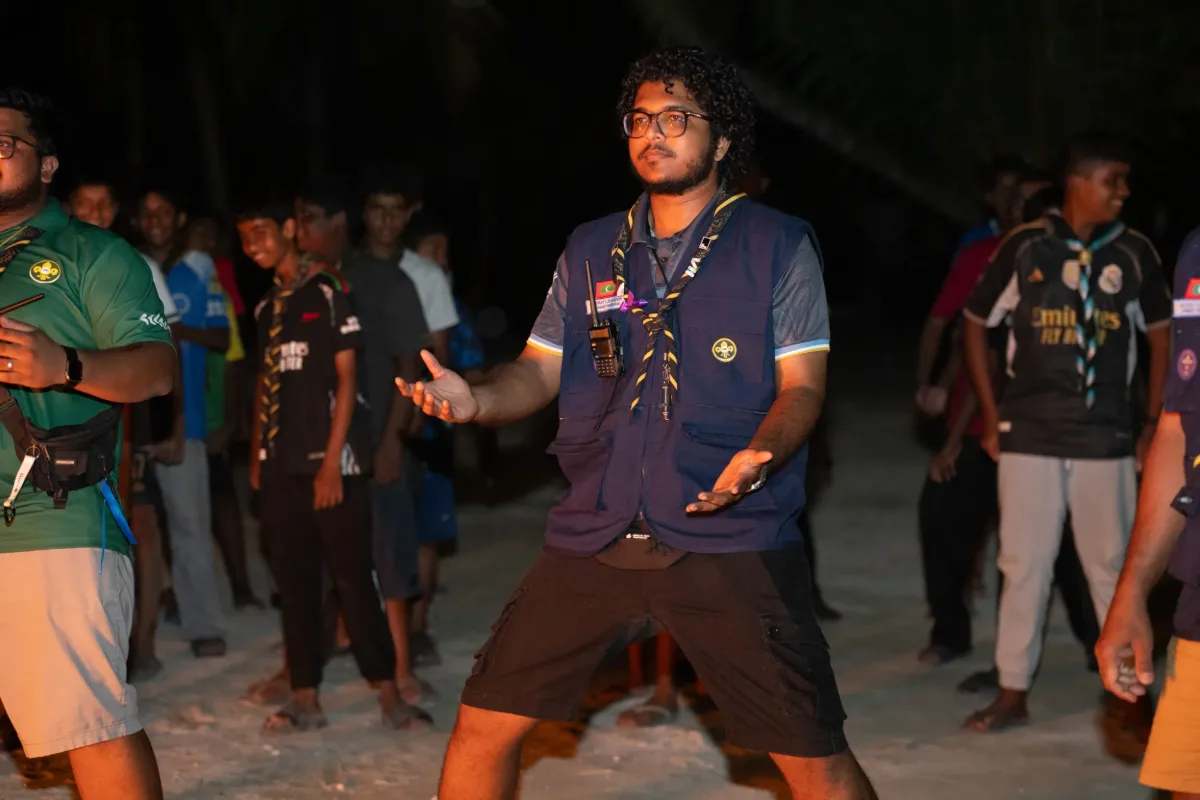 A scout leader addressing the group beside a campfire at the Veshi Ugenemaa 9 camp in V. Felidhoo