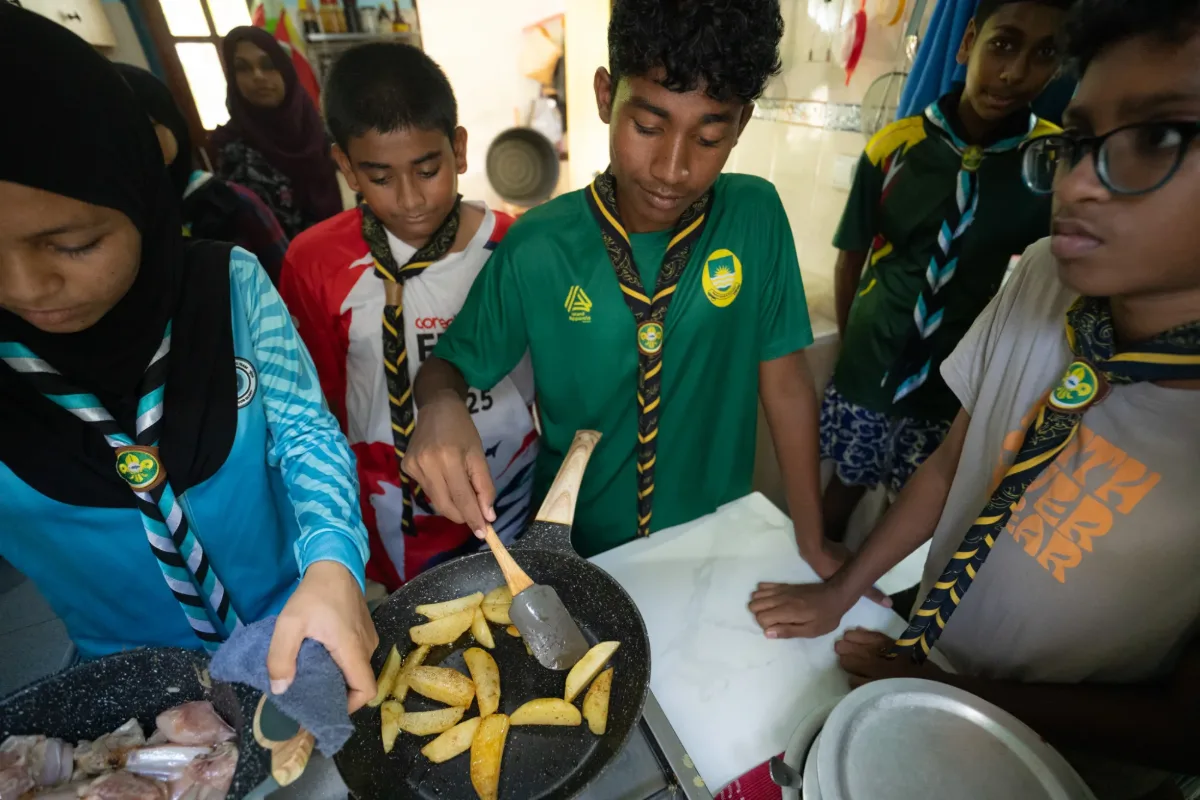 Scouts preparing and cooking a meal together during the camp
