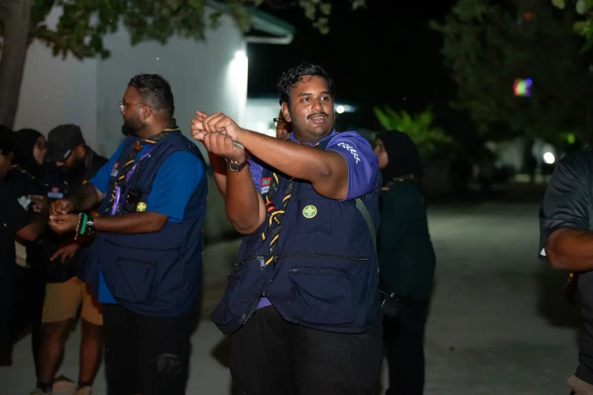 A scout leader addressing the group beside a campfire at the Veshi Ugenemaa 9 camp in V. Felidhoo