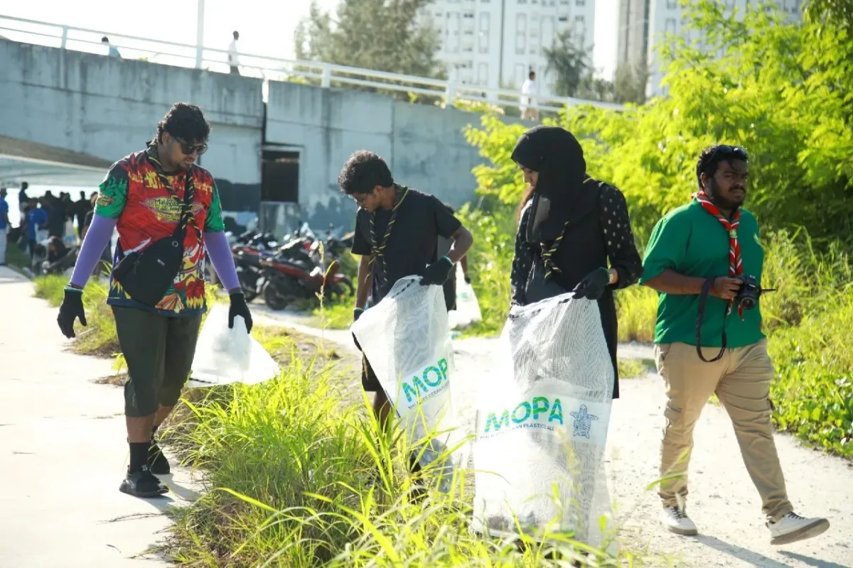 Three Rovers carrying collection sacks and searching for litter along the coastal walkway during the cleanup.