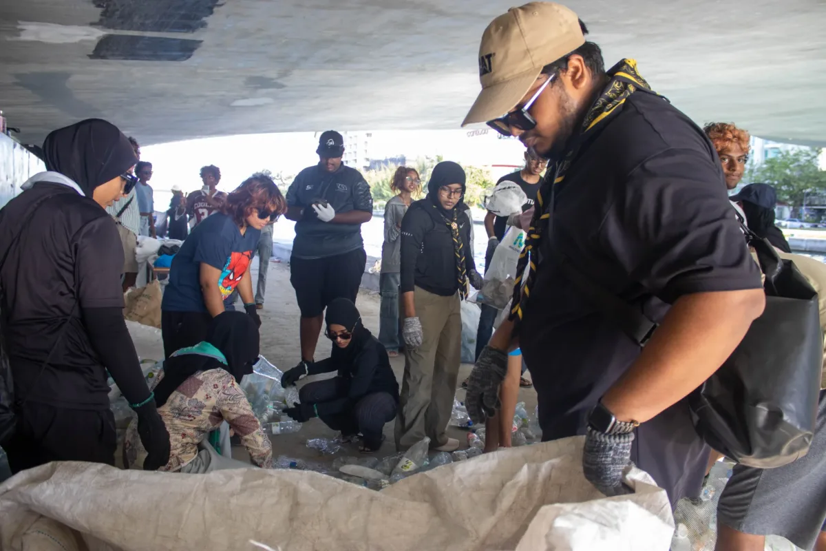 Rovers and community volunteers working together to collect and sort rubbish beneath a bridge.